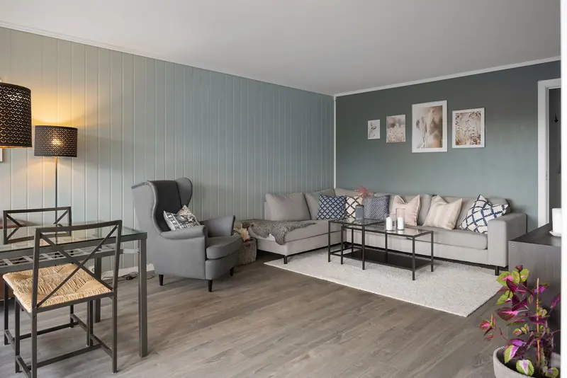 A one-bedroom living room with gray walls and a reading chair