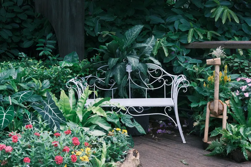 A white bench tucked among the garden greenery