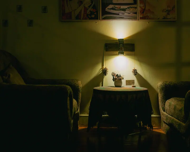 A lamp-lit sitting room with armchairs and a small table
