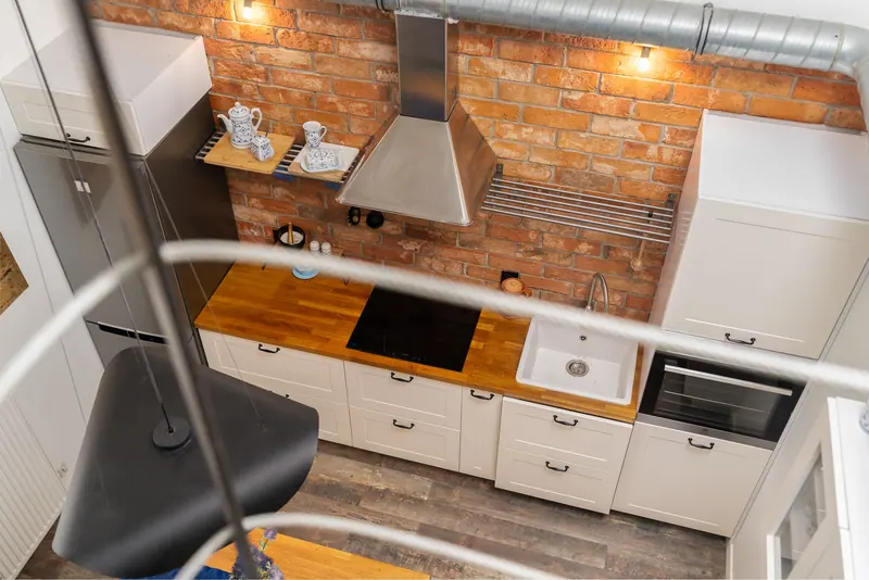 A loft kitchen with a brick wall and butcher-block counter