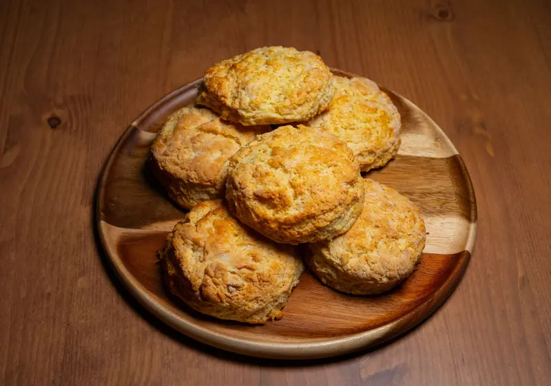 A plate of fresh-baked biscuits on a wooden board