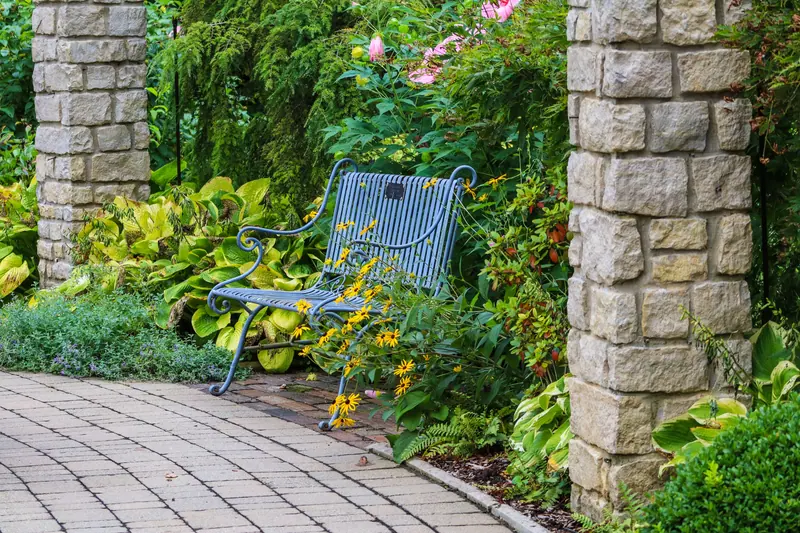 A bench between the stone pillars at the courtyard gate