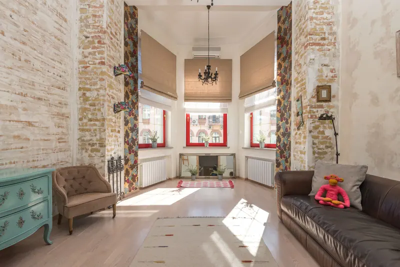 Bright and spacious loft living room with brickwork, modern decor, and stylish furnishings.