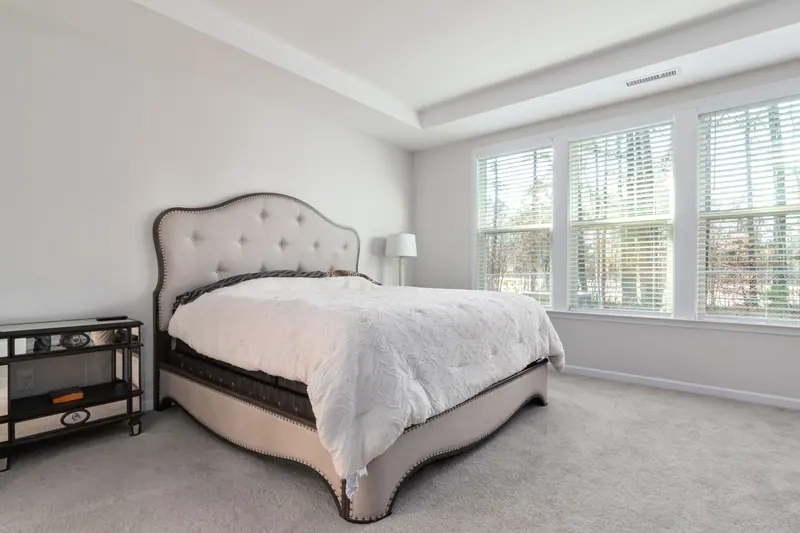Bright and cozy bedroom featuring a luxurious bed and large windows with natural light.