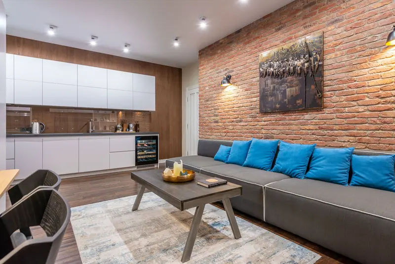 Stylish living room featuring a brick wall, modern furniture, and cozy lighting.