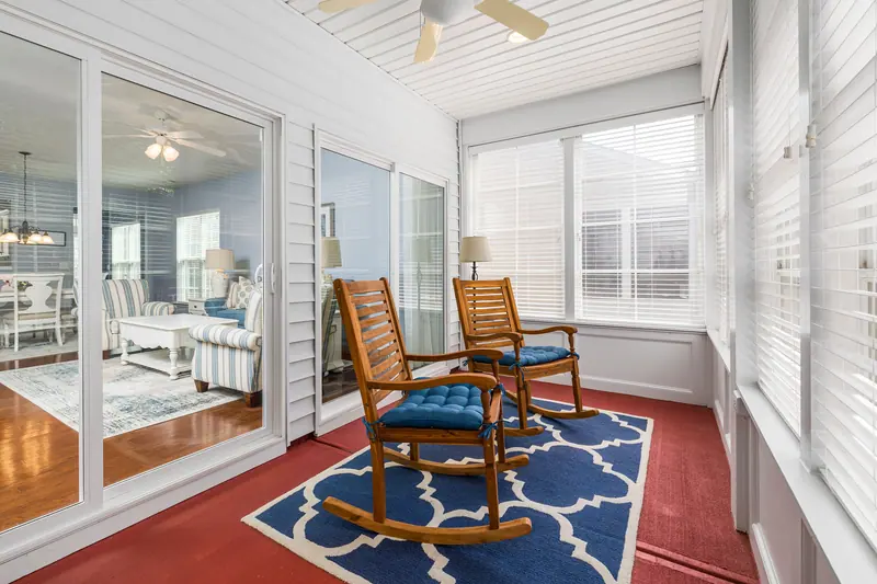 The sunroom with rocking chairs and glass doors to the courtyard
