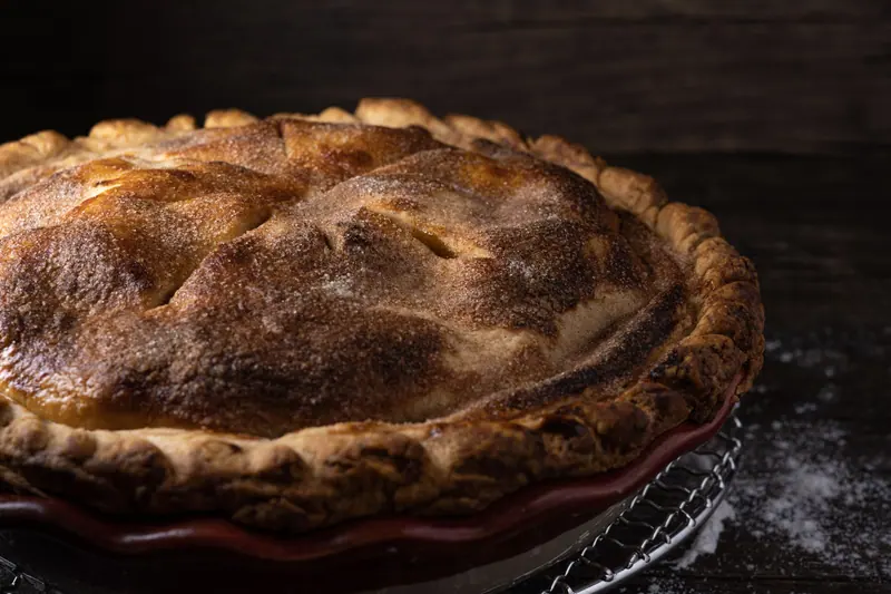 A homemade apple pie cooling on a rack