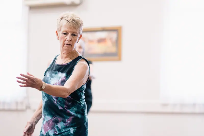 A patient working on balance and arm reach in the group exercise class