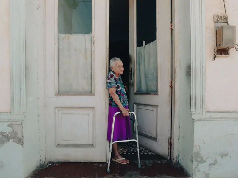A guest stepping out her front door with her walker