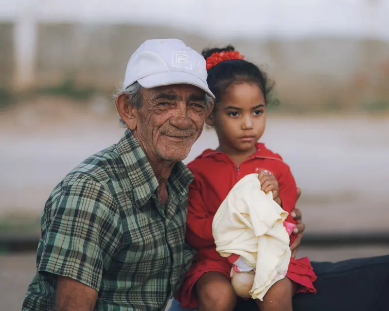 A resident with his granddaughter on his knee