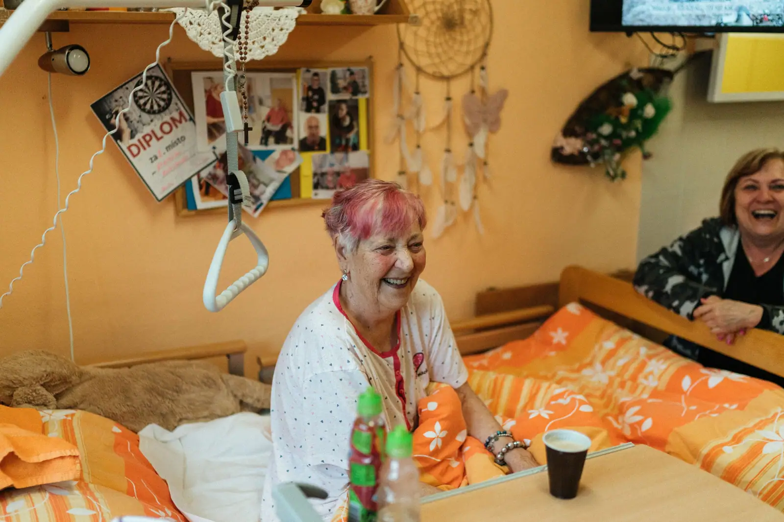 A resident laughing with her roommate in their room full of family photos