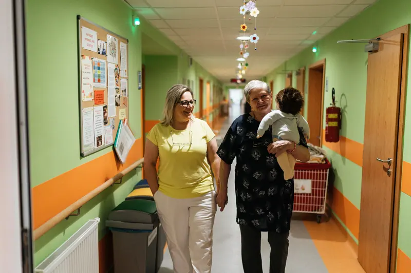 An aide walking with a resident down the hall after therapy