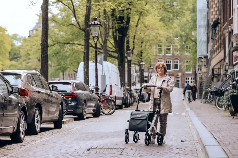 A former patient out for a walk with her rollator