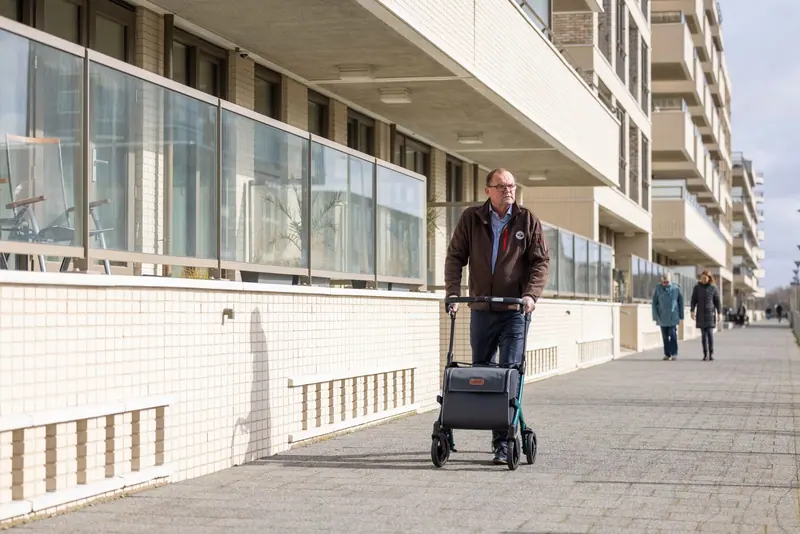A former patient out on the sidewalk with his rollator