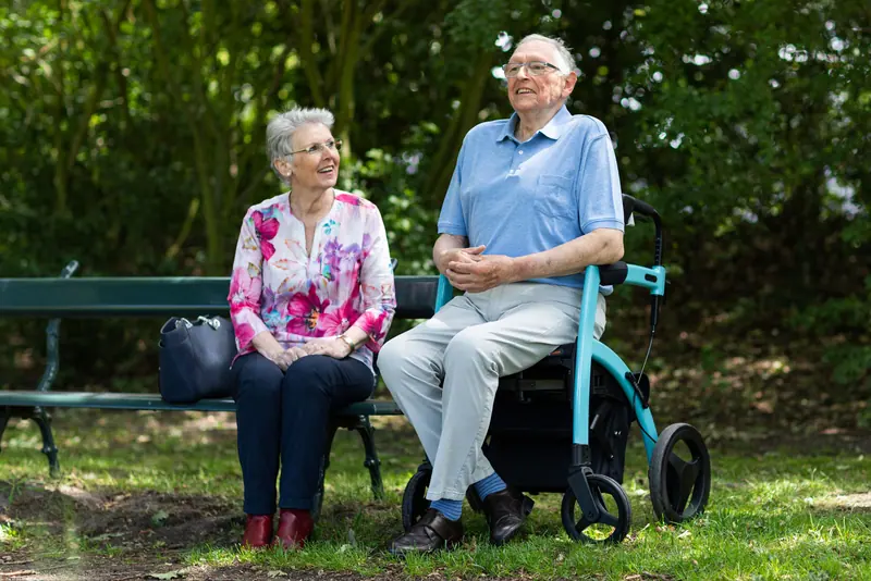 A couple resting on a garden bench during a walk