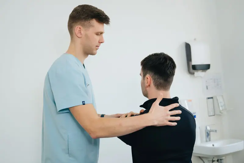 A physical therapist working on a patient's shoulder mobility