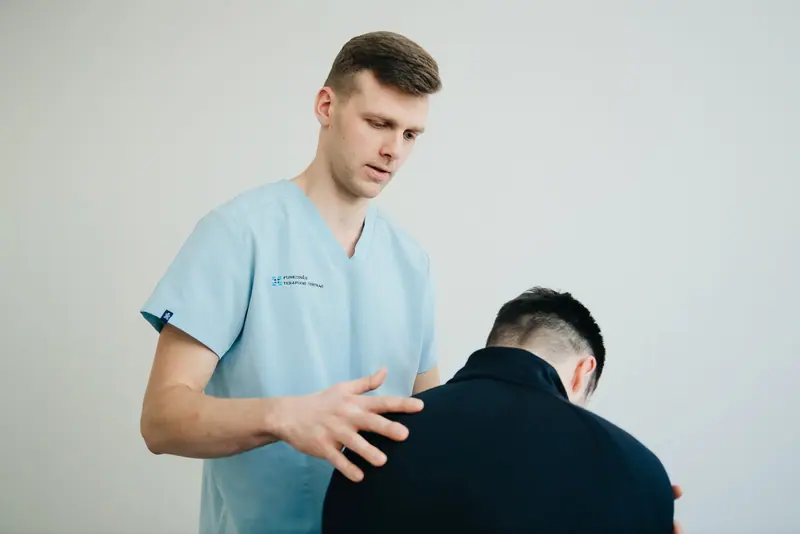 A physical therapist checking a patient's posture