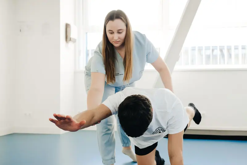 A therapist guiding a guest's arm through a stretch