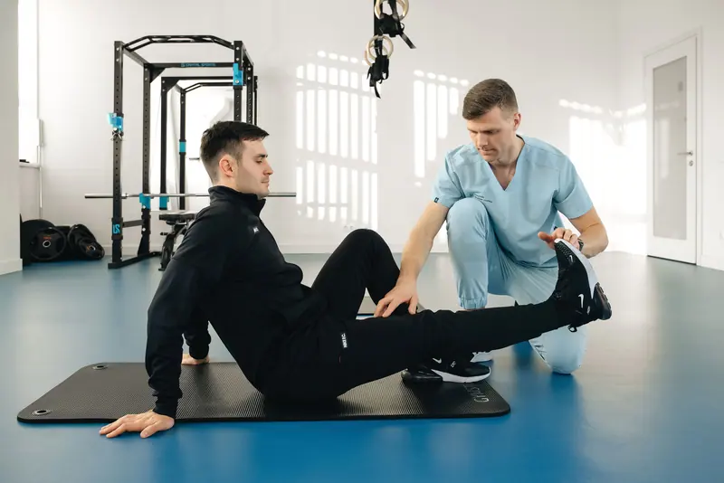 A guest working through floor exercises with his therapist