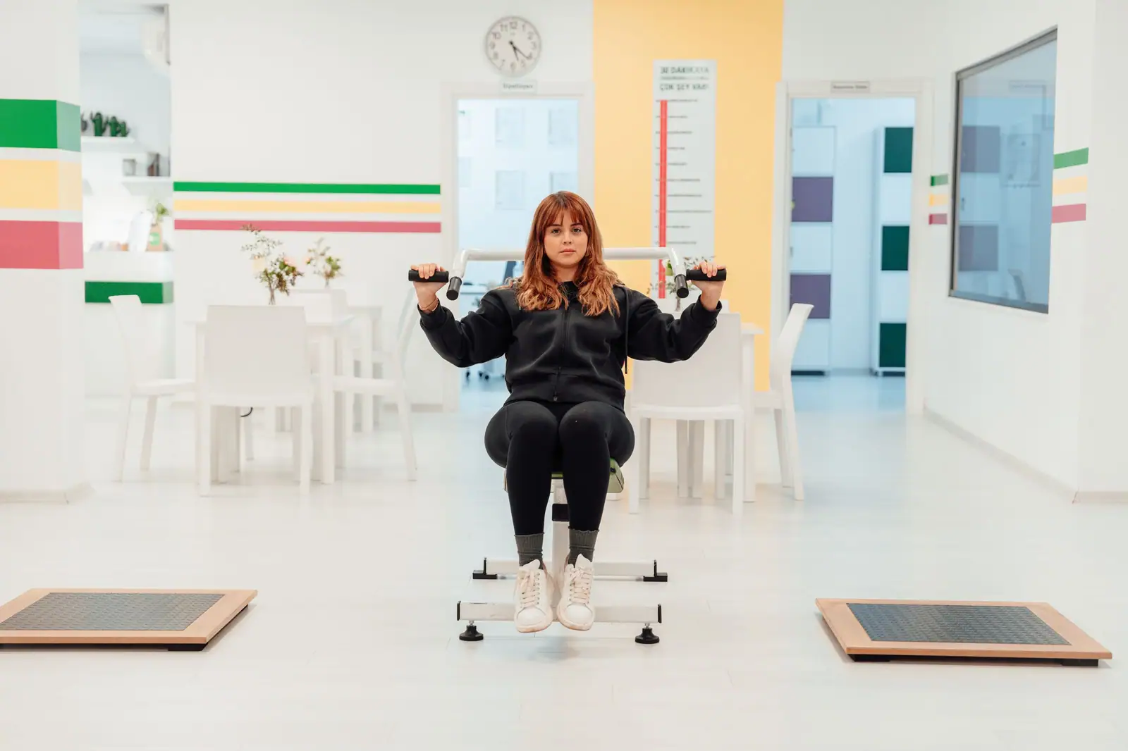 The bright therapy gym with a patient working with hand weights