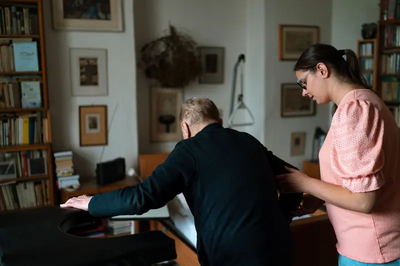 A therapist watching a resident reach for the shelf during a balance session