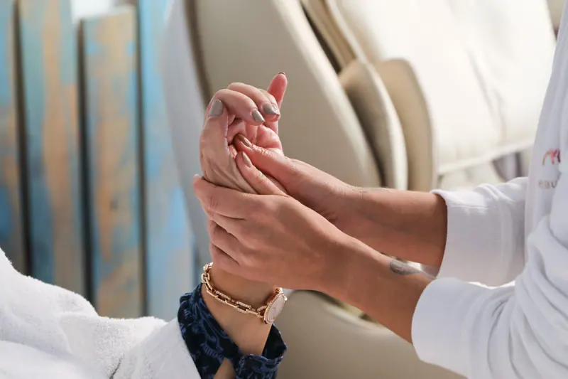 A therapist working on a guest's hand