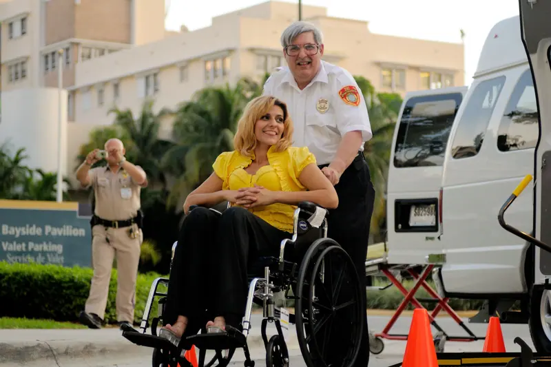 A guest in a wheelchair heading home with a smile on discharge day