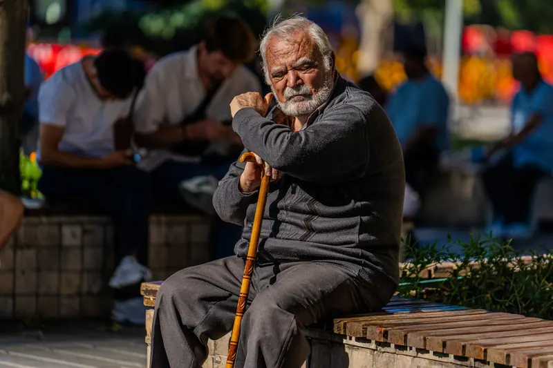 A resident resting on his cane outside the dining room