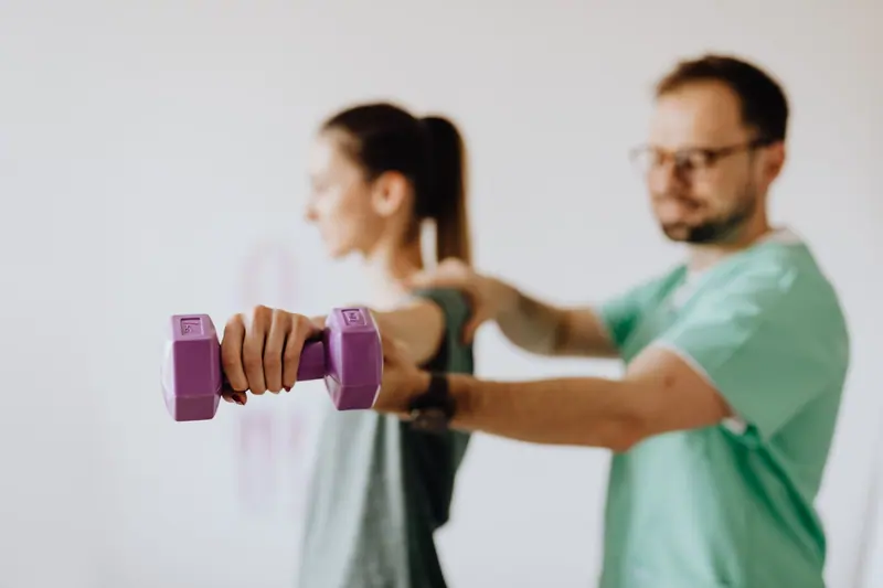 A guest lifting a light dumbbell with her therapist's guidance