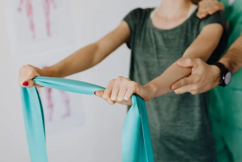 An occupational therapist guiding an arm exercise with a band