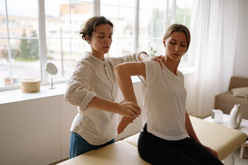 A therapist working with a patient by the window of the treatment room