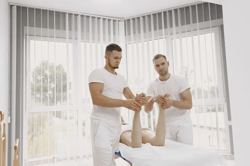 Two therapists working on a patient's ankle