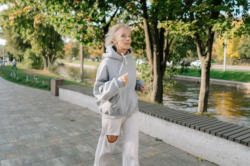 A woman jogging gently along the riverside path