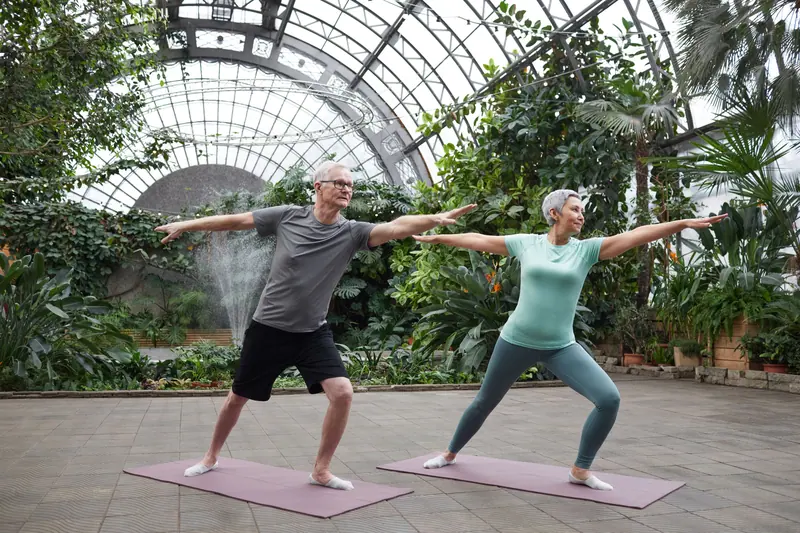 A couple stretching together in the sunny garden room