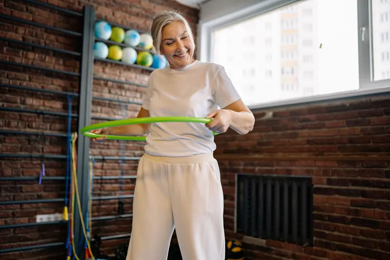 A patient working with a hula hoop in group class