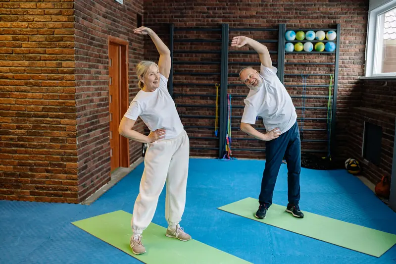 A couple doing side bends in the morning group class