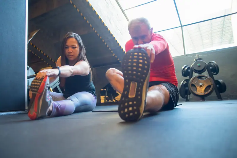 A patient stretching his hamstrings with his therapist