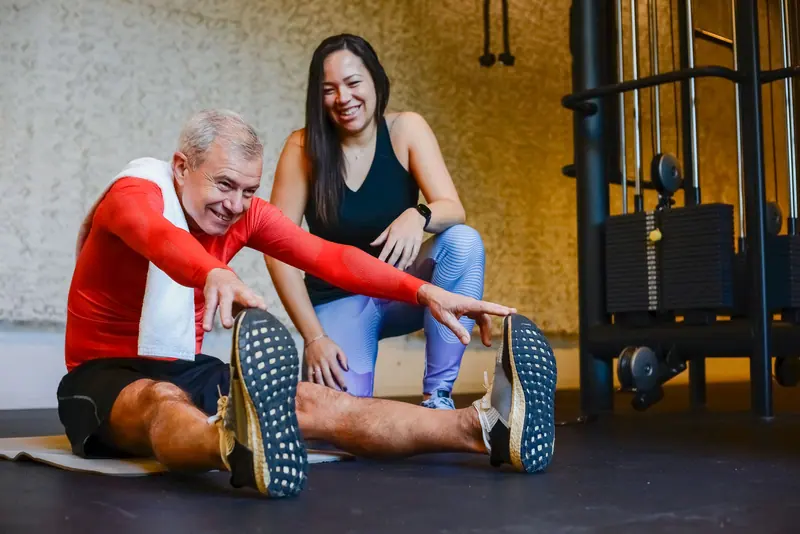 A therapist coaching a guest through hamstring stretches