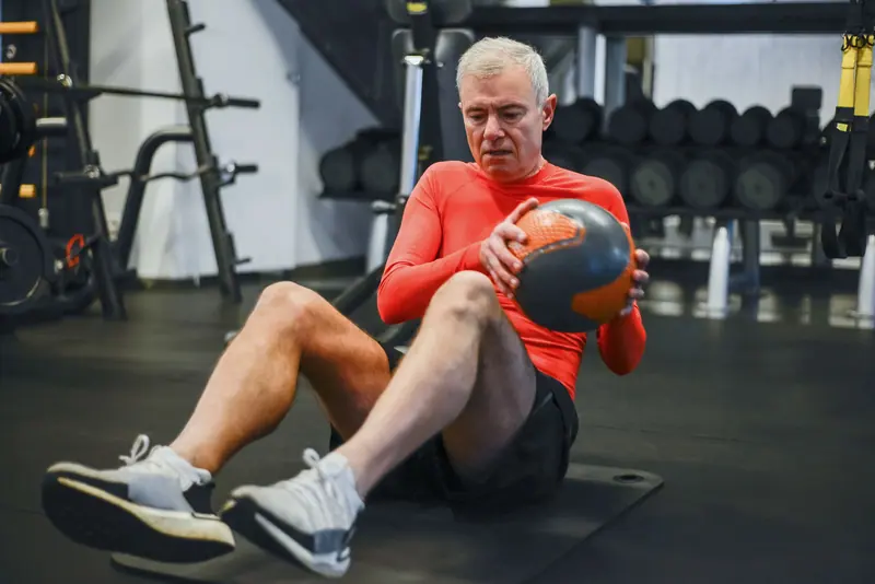 A patient doing medicine-ball twists
