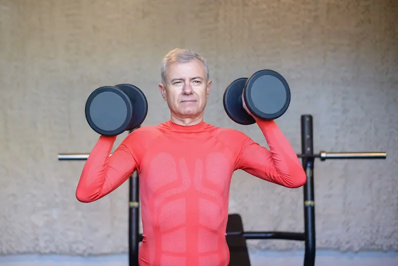 A patient pressing dumbbells overhead