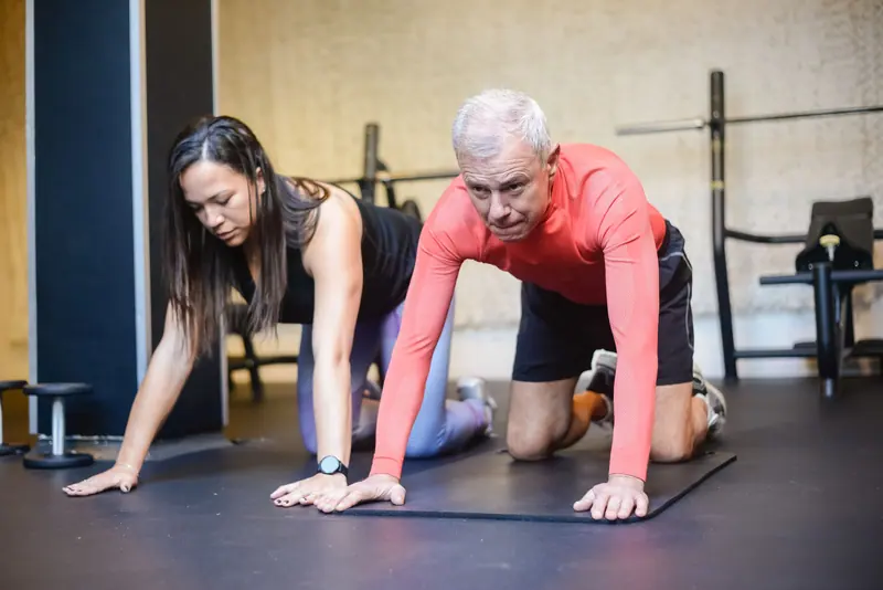 A therapist and patient doing a floor stretch together