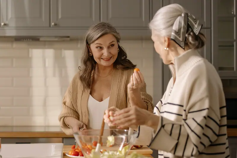 A daughter and her mother cooking together after discharge