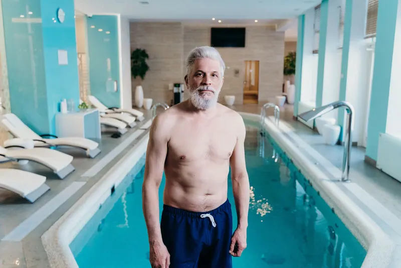 A patient standing by the warm-water pool before his session