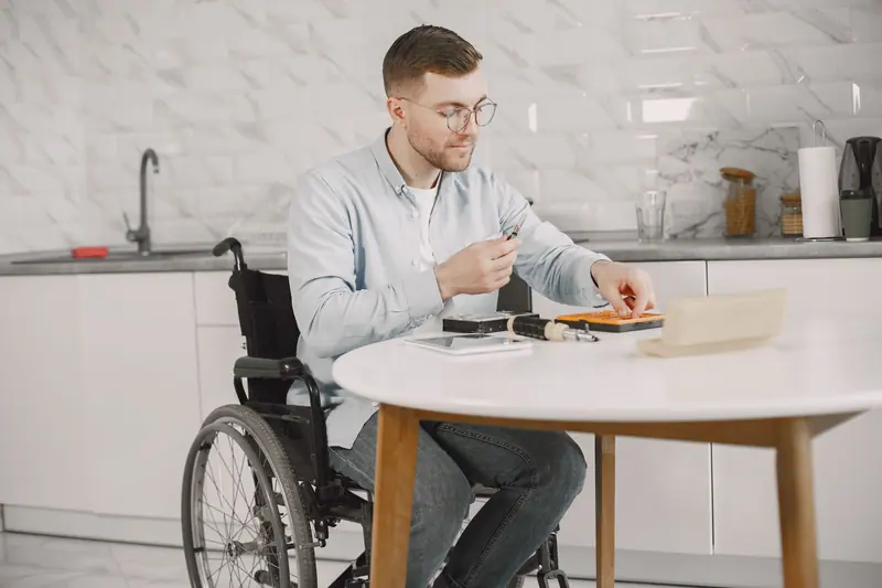 A guest in his wheelchair at the kitchen table