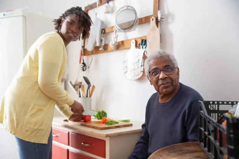 A guest chopping vegetables in the practice kitchen with his OT
