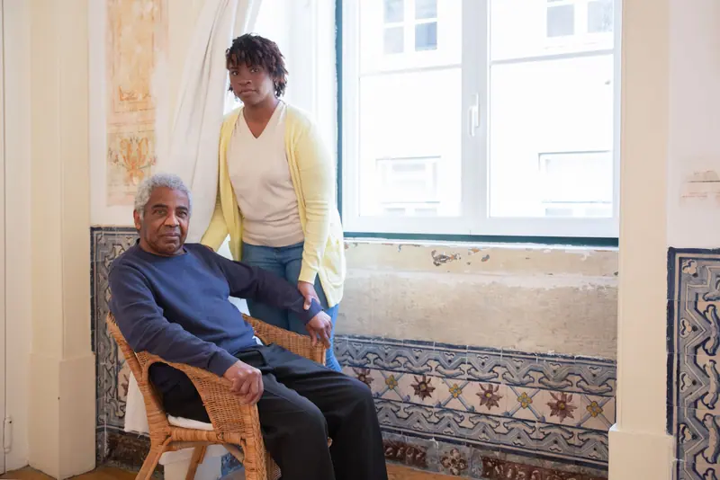A resident and his caregiver by the tiled window seat