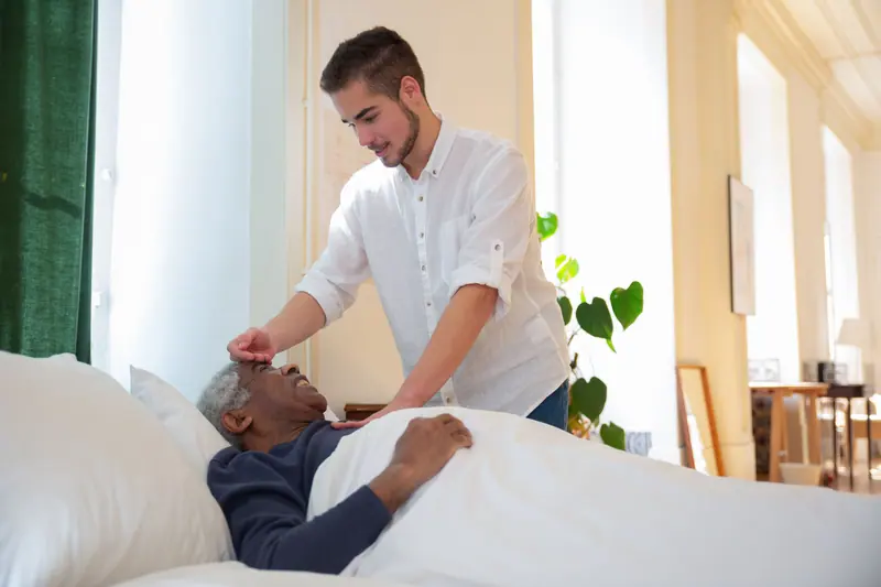A therapist checking on a guest in bed