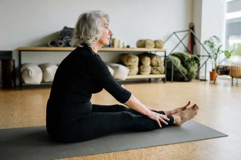 A patient doing a seated stretch in the studio