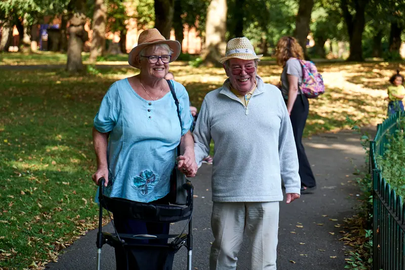 A couple on an afternoon walk with her rollator