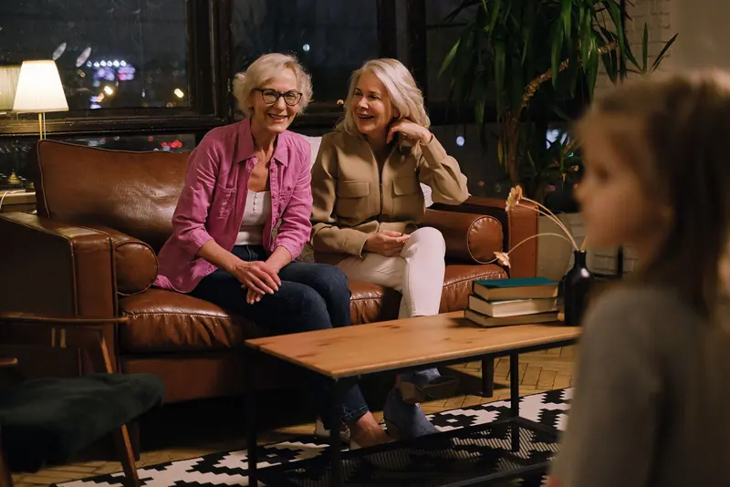Two friends laughing on the leather sofa